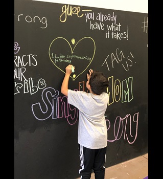 Young student writing on chalk board