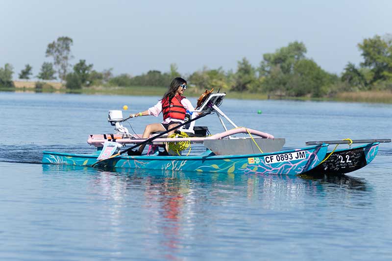 Girl driving solar powered boat on a lake.