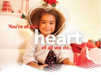 Young girl sitting on a couch and smiling with a heart graphic around her face.