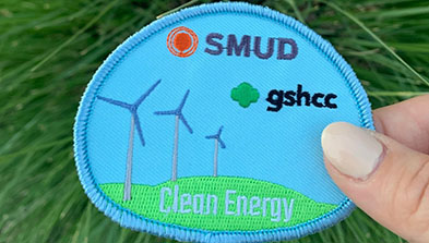 Girls Scouts Heart of Central California's embroidered patch with the SMUD logo, wind turbines and "Clean Energy"