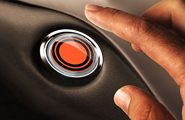 Finger hovering over push start button with the SMUD logo.
