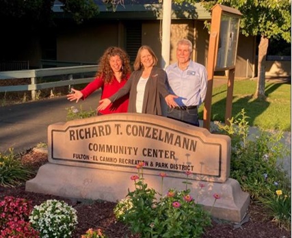 3 people standing in front of Richard T. Conzelmann Community Park sign
