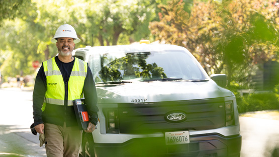 SMUD fieldworker outside next to a SMUD truck.