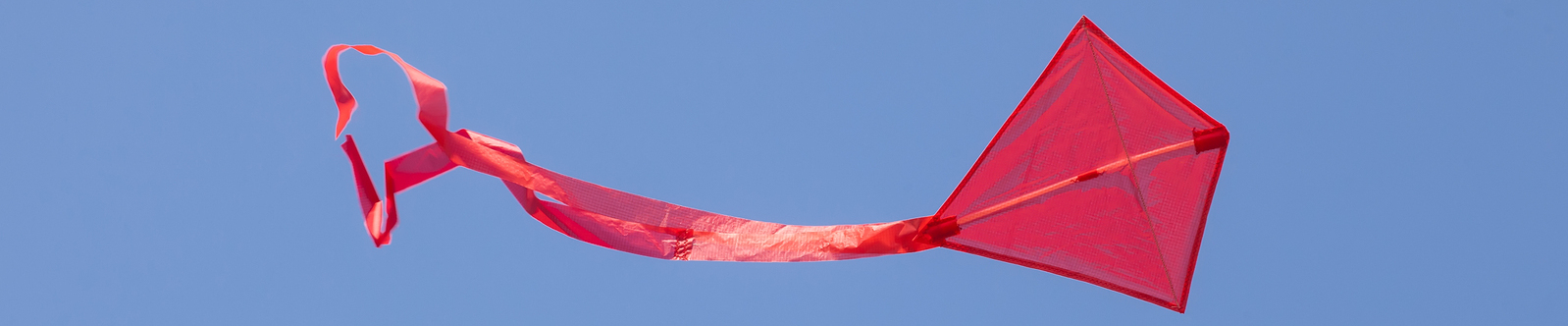 red kite flying in blue sky