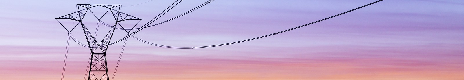 Power lines and tower at sunrise with purple sky